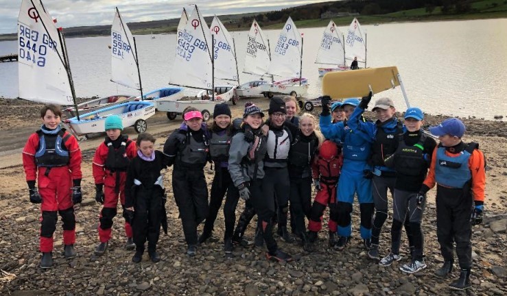 Group of junior Optimist sailors smiling for the camera on shore at a Regional Training Group weekend, DRSC 2021.