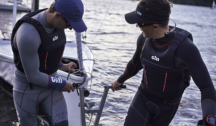 2 people taking their boat out of the water wearing gill merchandise