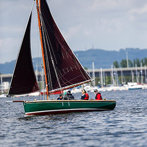 wide shot of a small sailing boat off the coast of Cardiff