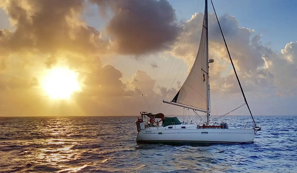 wide shot of sailing yacht on the open sea during sunset