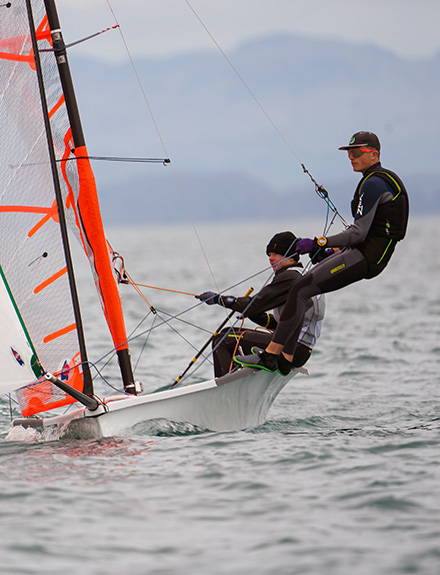 action shot of two young sailor taking part in dinghy race on the open water