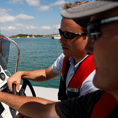 close-up of man driving boat on a sunny day