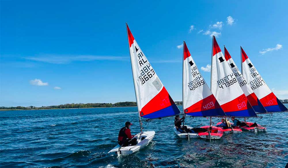  four small sailing dinghies on the open water