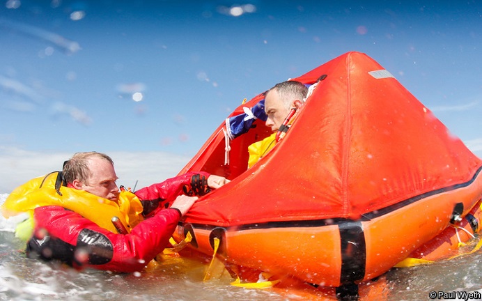 Two men on a liferaft wearing lifejackets